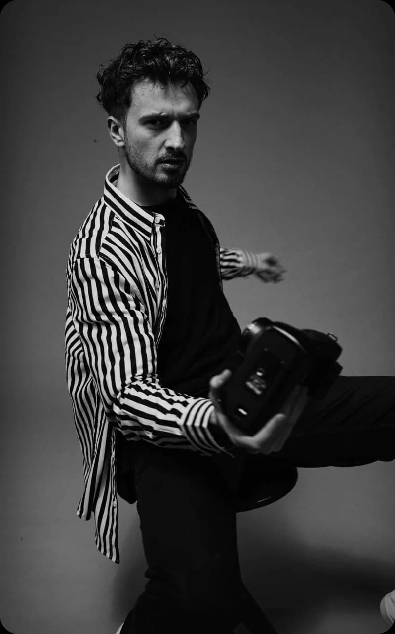 Black and white portrait of a man holding a camera